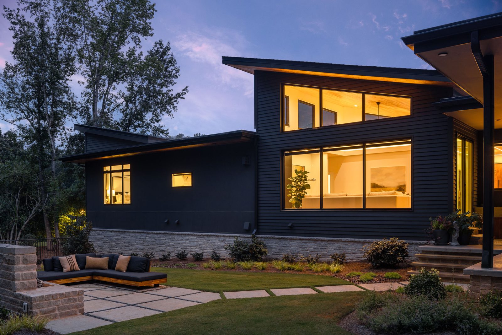Rear elevation at twilight above the paver terrace — The Ortiz Home, custom home built by Ironwood Construction Group in Sugar Hill, Georgia