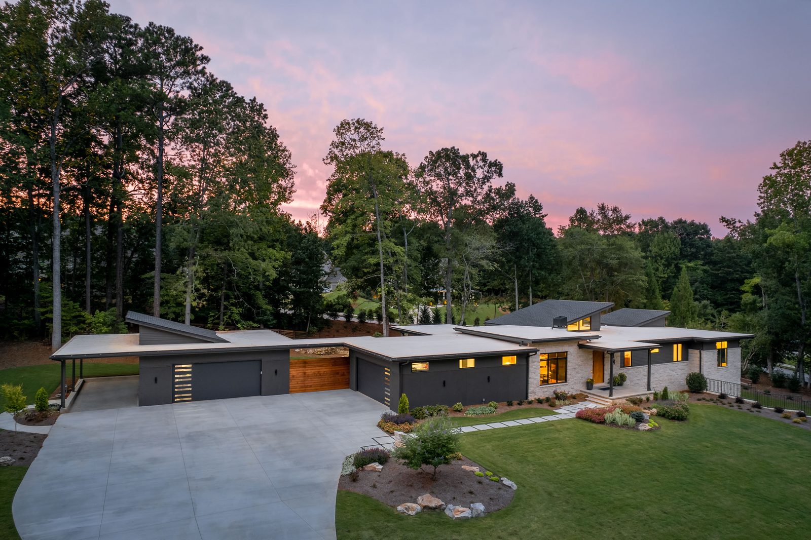 Front elevation at twilight with the driveway sweeping in — The Ortiz Home, custom home built by Ironwood Construction Group in Sugar Hill, Georgia
